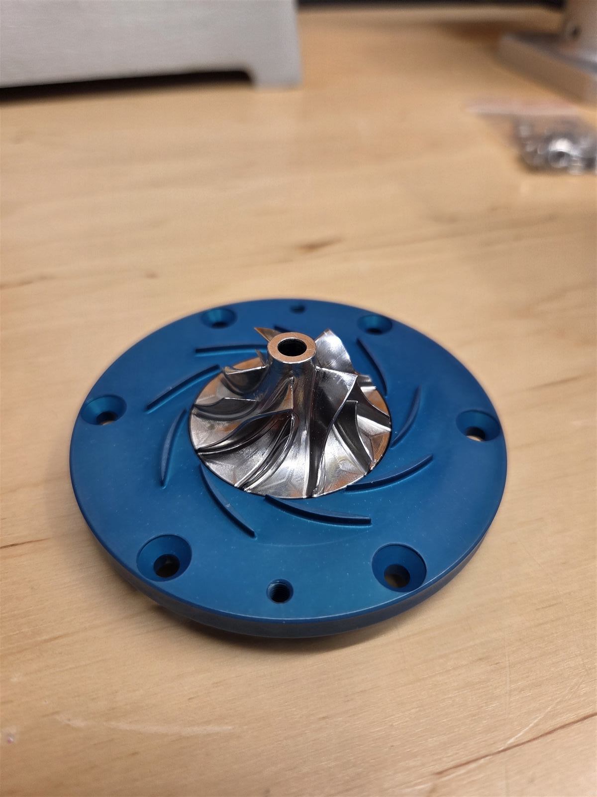 Centrifugal compressor impeller mounted in a blue diffuser housing