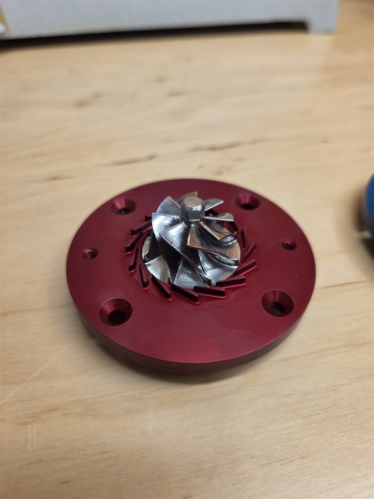 Centrifugal compressor impeller mounted in a red diffuser housing